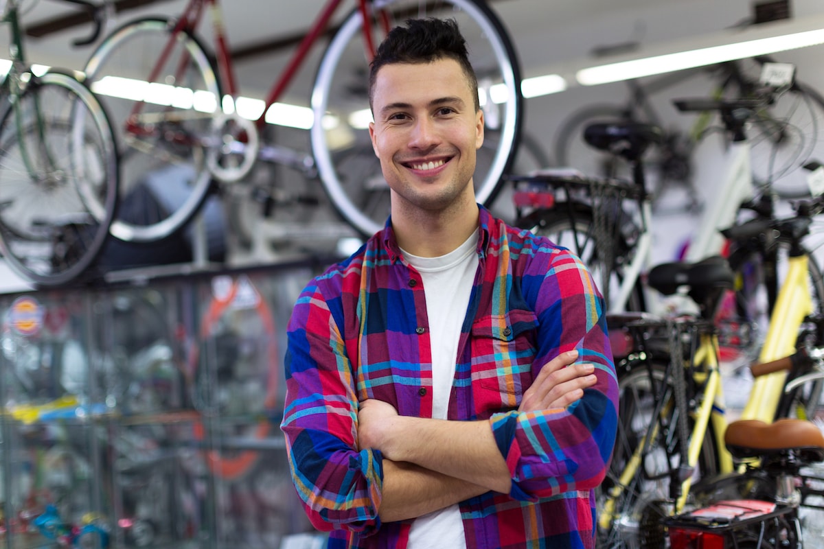 Proud bike shop owner smiling at customers